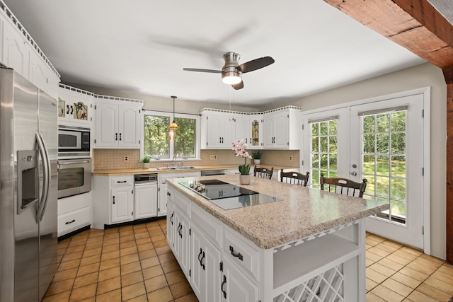 84 Kanungum Trl, Shelton, CT 06484 - kitchen with stainless steel appliances, light tile patterned floors, healthy amount of natural light, and backsplash