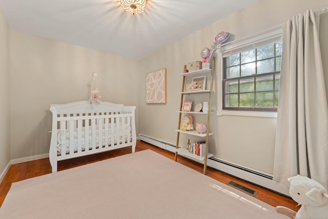 84 Kanungum Trl, Shelton, CT 06484 - bedroom featuring wood finished floors, a nursery area, and baseboard heating