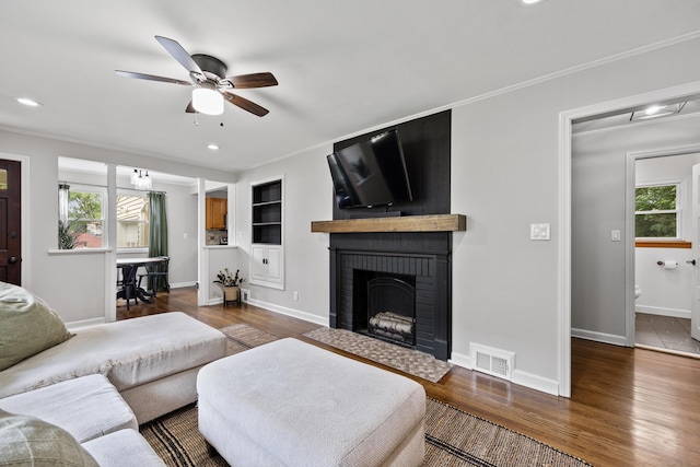 96 Douglas Dr, Meriden, CT 06451 - living area featuring healthy amount of natural light, a ceiling fan, crown molding, wood finished floors, and a fireplace