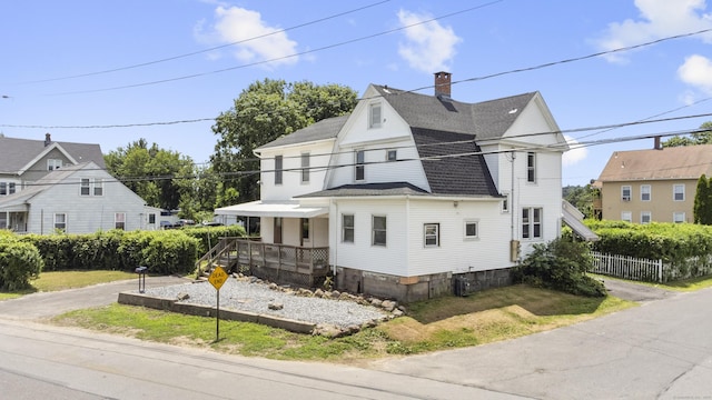 124 Geddes Ter, Waterbury, CT 06708 - view of front facade featuring roof with shingles, a chimney, and a porch