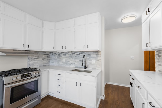 124 Geddes Ter, Waterbury, CT 06708 - kitchen with gas stove, under cabinet range hood, dark wood-style floors, and light stone counters