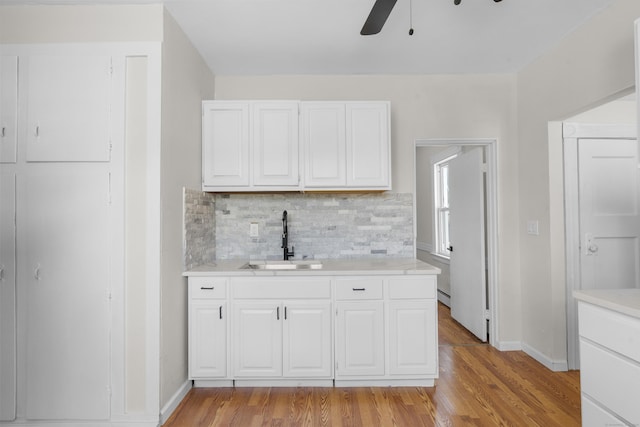 124 Geddes Ter, Waterbury, CT 06708 - kitchen with light wood-style floors, light countertops, a ceiling fan, decorative backsplash, and white cabinets