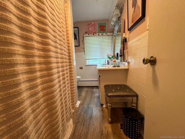 860 Suffield St, Suffield, CT 06078 - full bathroom featuring tile walls, wood finished floors, a baseboard heating unit, a wainscoted wall, and a shower with curtain