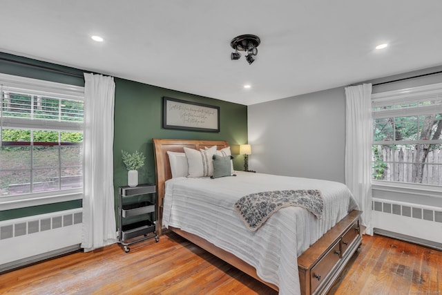 140 Ridgewood Rd, East Hartford, CT 06118 - bedroom with radiator, multiple windows, wood-type flooring, and recessed lighting