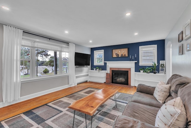 140 Ridgewood Rd, East Hartford, CT 06118 - living area featuring radiator, a fireplace, wood finished floors, and recessed lighting
