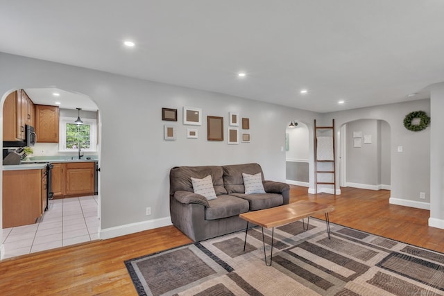 140 Ridgewood Rd, East Hartford, CT 06118 - living room featuring arched walkways, recessed lighting, and light wood finished floors