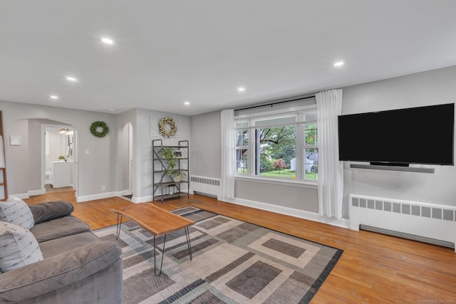 140 Ridgewood Rd, East Hartford, CT 06118 - living area featuring radiator heating unit, arched walkways, wood finished floors, and recessed lighting