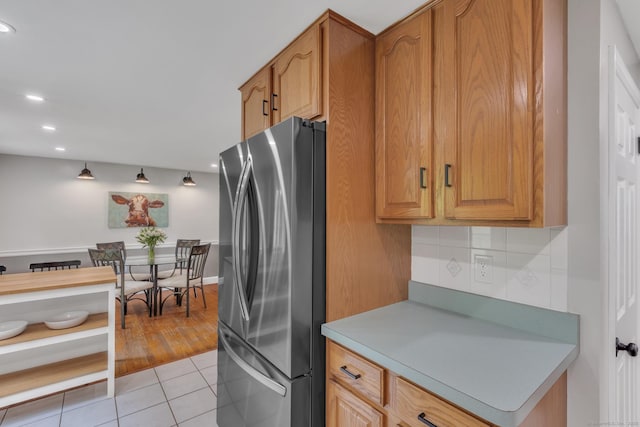 140 Ridgewood Rd, East Hartford, CT 06118 - kitchen featuring freestanding refrigerator, light tile patterned floors, light countertops, recessed lighting, and brown cabinets