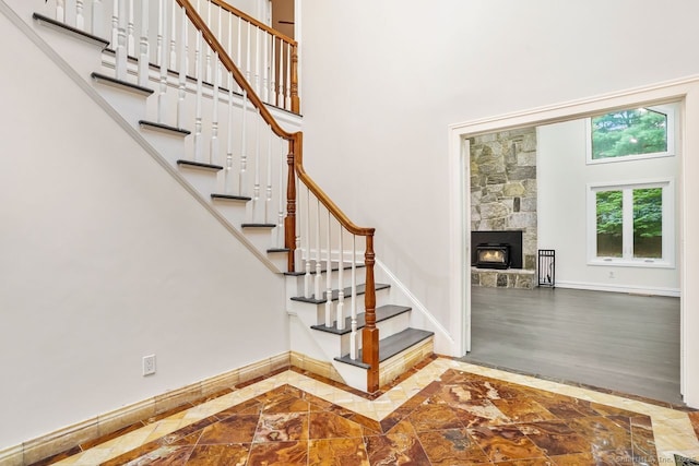 45 Hunting Ridge Rd, Easton, CT 06612 - staircase featuring inlaid floor details, a towering ceiling, and a fireplace
