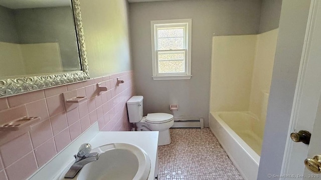 full bathroom with a baseboard radiator, tile walls, vanity, and tile patterned floors