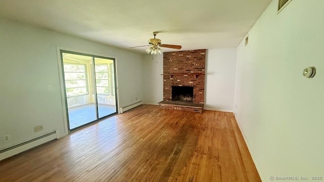 unfurnished living room with baseboard heating, a baseboard radiator, wood finished floors, ceiling fan, and a brick fireplace