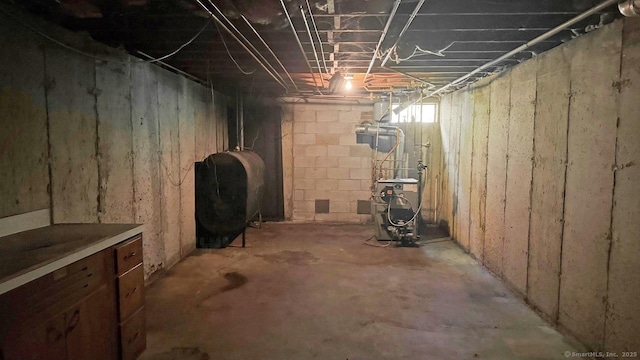 unfinished below grade area with oil tank and a heating unit