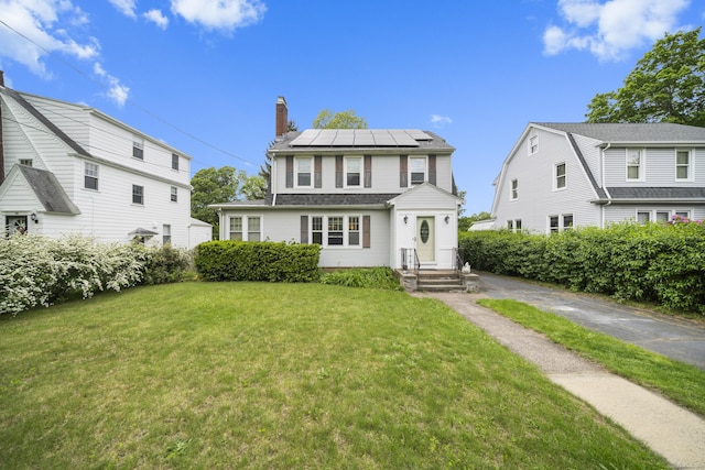 114 Kneeland Rd, New Haven, CT 06512 - view of front of home with a chimney, solar panels, and a front lawn