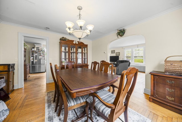 114 Kneeland Rd, New Haven, CT 06512 - dining room with radiator, a chandelier, crown molding, light wood-style flooring, and arched walkways