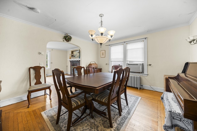 114 Kneeland Rd, New Haven, CT 06512 - dining space with radiator, arched walkways, a chandelier, plenty of natural light, and ornamental molding