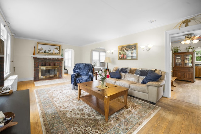 114 Kneeland Rd, New Haven, CT 06512 - living room with light wood-type flooring, arched walkways, a brick fireplace, ornamental molding, and ceiling fan