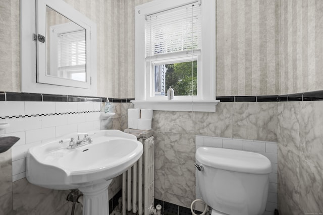 114 Kneeland Rd, New Haven, CT 06512 - half bathroom featuring radiator, tile walls, wainscoting, and wallpapered walls