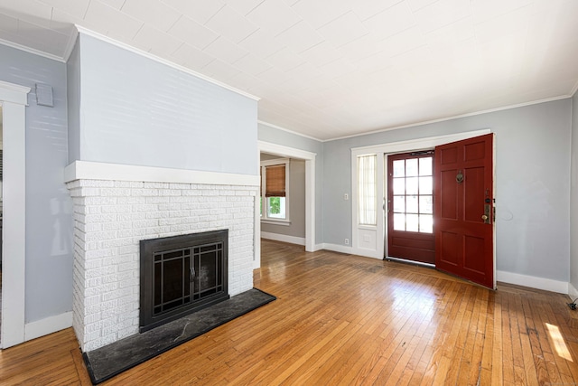 38 Francis Ave, Hamden, CT 06517 - foyer entrance with crown molding, a brick fireplace, and hardwood / wood-style floors