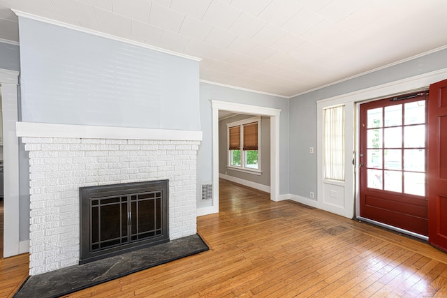 38 Francis Ave, Hamden, CT 06517 - entrance foyer with crown molding, wood-type flooring, and a fireplace