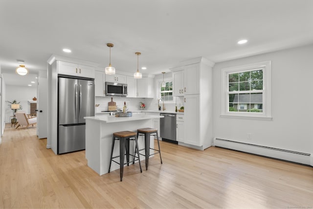 103 Perry Rd, Bristol, CT 06010 - kitchen featuring stainless steel appliances, a baseboard radiator, a kitchen island, white cabinets, and a kitchen breakfast bar