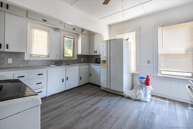 118 New Haven Ave, Derby, CT 06418 - kitchen featuring white fridge with ice dispenser, wood finished floors, wainscoting, and decorative backsplash