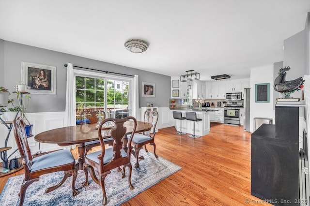 51 Olde Village Cir Unit 51, Wallingford, CT 06492 - dining room featuring light wood-type flooring and wainscoting