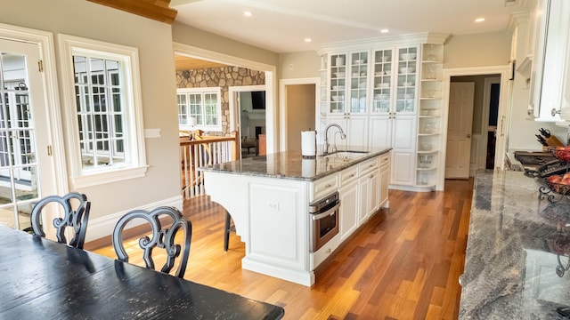 7 Taunton Ln, Newtown, CT 06470 - kitchen with open shelves, light wood-type flooring, white cabinetry, oven, and glass insert cabinets