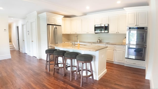 7 Taunton Ln, Newtown, CT 06470 - kitchen with stainless steel appliances, recessed lighting, dark wood-style flooring, a kitchen bar, and a center island with sink