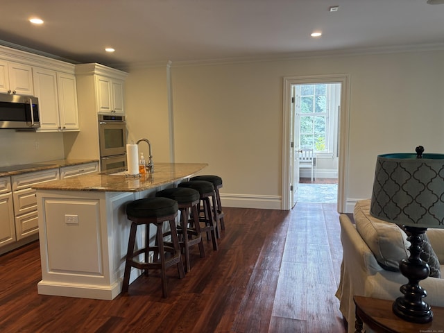 7 Taunton Ln, Newtown, CT 06470 - kitchen with appliances with stainless steel finishes, ornamental molding, light stone counters, dark wood-style floors, and white cabinets