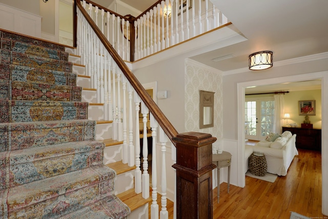 37 Giles Hill Rd, Redding, CT 06896 - staircase with ornamental molding, wood finished floors, a decorative wall, and wainscoting