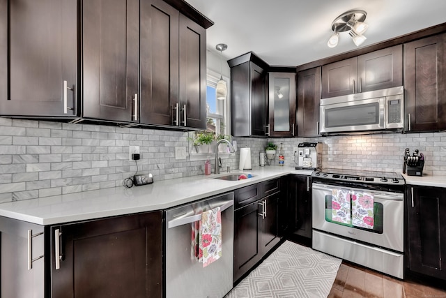 66 Atwood St Apt 16, Plainville, CT 06062 - kitchen featuring stainless steel appliances, backsplash, light countertops, dark brown cabinetry, and pendant lighting
