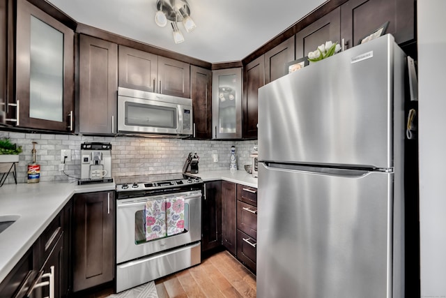 66 Atwood St Apt 16, Plainville, CT 06062 - kitchen featuring appliances with stainless steel finishes, dark brown cabinets, light countertops, light wood-type flooring, and tasteful backsplash