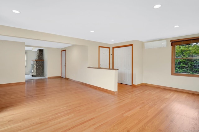 170 Scantic Meadow Rd, South Windsor, CT 06074 - unfurnished living room with a wall mounted AC, light wood-style flooring, and recessed lighting