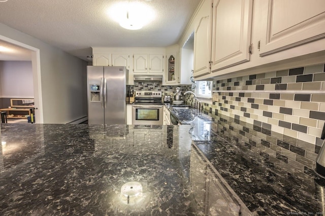 1018 Long Hill Rd, Middletown, CT 06457 - kitchen with appliances with stainless steel finishes, under cabinet range hood, tasteful backsplash, a textured ceiling, and dark stone counters