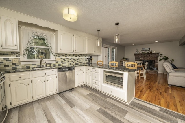 1018 Long Hill Rd, Middletown, CT 06457 - kitchen with appliances with stainless steel finishes, open floor plan, a peninsula, light wood finished floors, and a textured ceiling