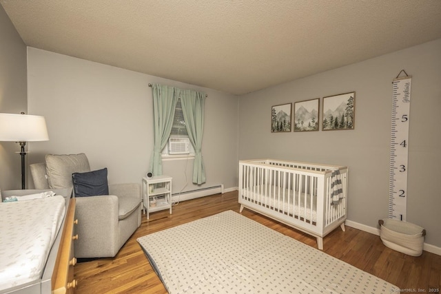 1018 Long Hill Rd, Middletown, CT 06457 - bedroom with a baseboard heating unit, wood finished floors, and a crib