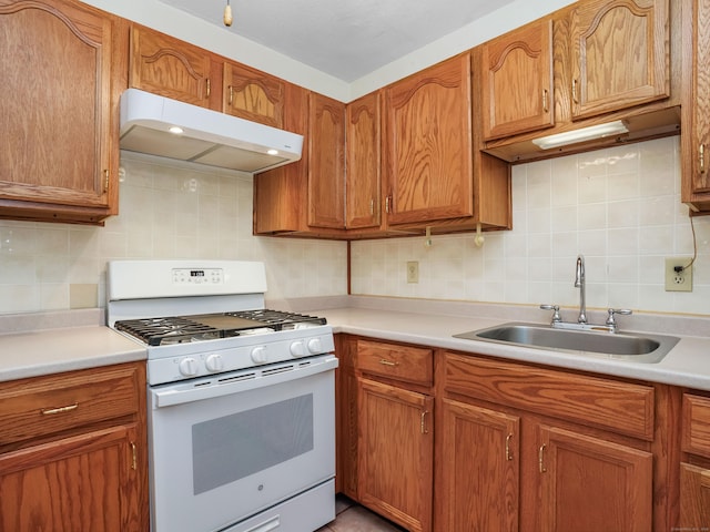 2600 Park Ave Unit 6H, Bridgeport, CT 06604 - kitchen with under cabinet range hood, white range with gas cooktop, decorative backsplash, and light countertops