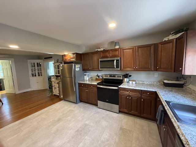 293 Torringford W St, Torrington, CT 06790 - kitchen featuring stainless steel appliances, recessed lighting, light stone countertops, light wood-type flooring, and dark brown cabinetry
