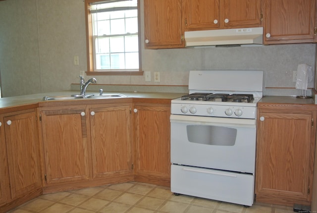 8 Barn Ln, Milford, CT 06460 - kitchen with under cabinet range hood, white gas range oven, light countertops, and brown cabinets