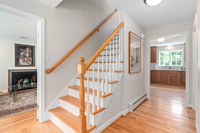 132 Deerwood Rd, Tolland, CT 06084 - staircase with baseboard heating, wood finished floors, and a fireplace