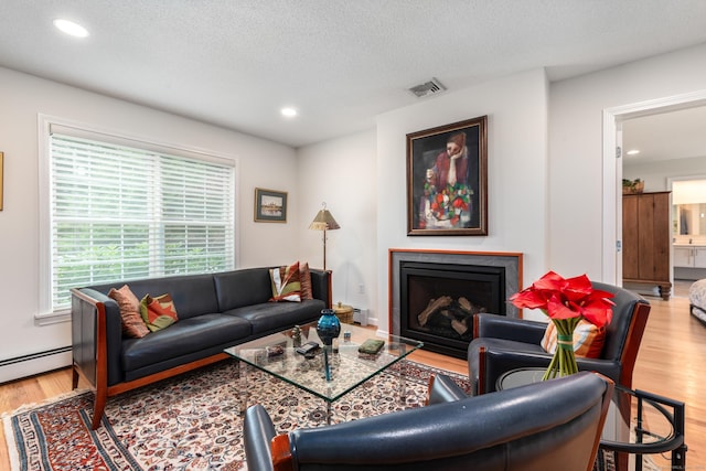 132 Deerwood Rd, Tolland, CT 06084 - living room featuring wood finished floors, a fireplace, recessed lighting, a textured ceiling, and a baseboard radiator
