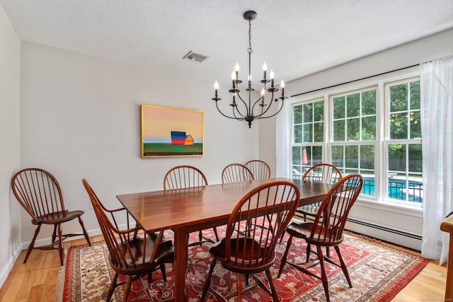132 Deerwood Rd, Tolland, CT 06084 - dining area with a chandelier, plenty of natural light, light wood-style floors, a textured ceiling, and baseboard heating