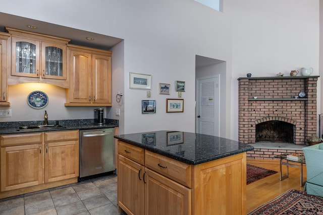 109 Old Farms Rd Unit 109, Torrington, CT 06790 - kitchen with stainless steel dishwasher, a towering ceiling, a fireplace, dark stone countertops, and glass insert cabinets