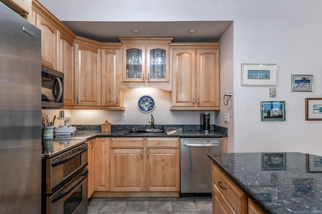 109 Old Farms Rd Unit 109, Torrington, CT 06790 - kitchen with appliances with stainless steel finishes, dark stone countertops, glass insert cabinets, and light tile patterned floors
