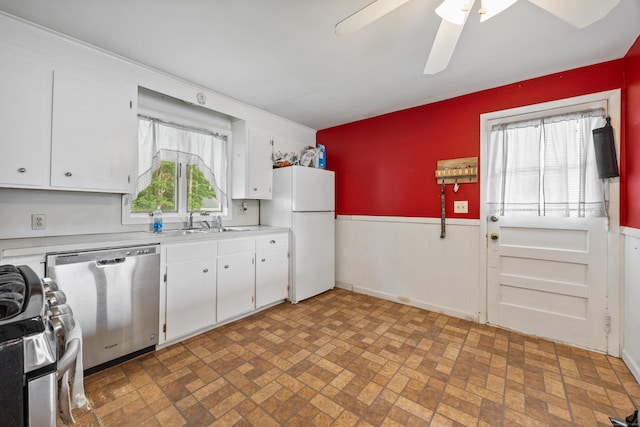 170 Celia Dr, Waterbury, CT 06705 - kitchen with appliances with stainless steel finishes, a wainscoted wall, light countertops, brick patterned floors, and white cabinetry