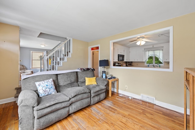 170 Celia Dr, Waterbury, CT 06705 - living room featuring wood-type flooring, a ceiling fan, stairs, and healthy amount of natural light