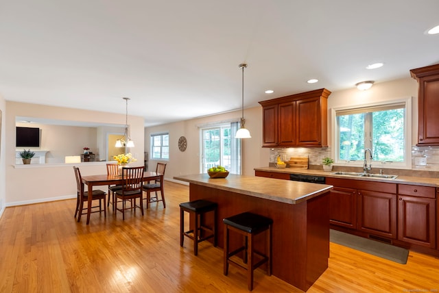 54 Round Hill Rd, Manchester, CT 06040 - kitchen featuring decorative backsplash, a breakfast bar area, a center island, light wood finished floors, and recessed lighting