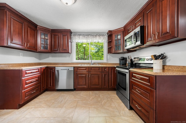 10 Harding Ave, Newington, CT 06111 - kitchen with stainless steel appliances, glass insert cabinets, light countertops, dark brown cabinets, and a textured ceiling