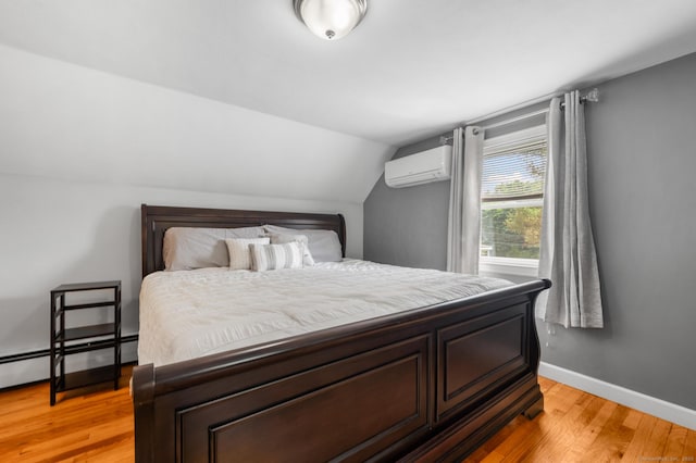 10 Harding Ave, Newington, CT 06111 - bedroom with an AC wall unit, light wood-style floors, vaulted ceiling, and a baseboard radiator