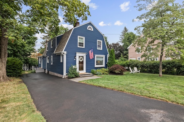 66 Concord St, West Hartford, CT 06119 - colonial inspired home featuring a gambrel roof, driveway, entry steps, a front lawn, and a chimney